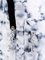 Mochila con estampado de manchas grises sobre fondo blanco, con bolsillo frontal y cierre negro.