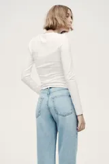 Jean tobillero de cinco bolsillos en denim de algodón rígido, con piernas rectas de corte holgado y cintura de tiro alto con cierre y botón.