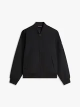 Campera bomber Tommy Hilfiger de color negro, confeccionada con tejido técnico de nailon reciclado y poliamida resistente al viento y la humedad ligera. Presenta diseño de corte clásico con cierre frontal de cremallera, cuello, puños y dobladillo en rib elástico, y dos bolsillos laterales de ojal. Incluye el logo monotipo bordado discretamente en el pecho.