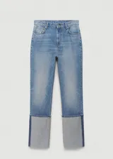 Pantalón de jean de corte recto y tiro medio, confeccionado en algodón. Presenta un diseño distintivo con el bajo vuelto en un tono de denim más claro y una costura lateral vertical en contraste.