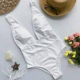 Malla enteriza blanca con escote en V profundo y tirantes anchos.