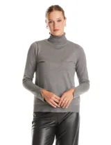 Polera de tejido fino con cuello alto, manga larga y detalle de tajo en los puños.