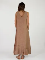 Vestido largo sin mangas, con escote en V, corte holgado y detalles de volados con flecos en el ruedo.