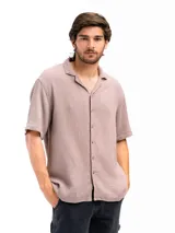 Camisa color crema de tela tetra de algodón, de corte suelto, manga corta y cuello cubano.