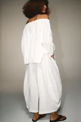 Pantalón blanco de tiro alto con cintura elástica ajustable mediante lazada interior. Presenta bolsillos laterales y un bajo con mucho volumen.