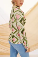 Camisa de manga larga con cuello clásico y cierre de botones. Estampado con motivos florales y geométricos en tonos crudo, azul y negro.