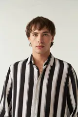 Camisa de mangas largas con estampado a rayas verticales en tonos verde oliva, blanco y azul. Corte regular y logo bordado en el pecho. Confeccionada en viscosa.