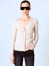 Cardigan de punto fino color beige, con escote en V y cierre frontal con botones.