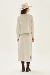 Falda larga de tejido bouclé color crudo, con cintura elástica y aberturas laterales en el bajo.