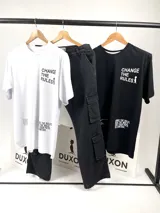 Remera blanca de algodón con estampa en el frente con la frase "CHANGE THE RULES" y un dibujo de una persona. En la parte inferior tiene otra estampa con texto ilegible.