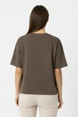 Remera de algodón color negro con cuello redondo y mangas cortas. Presenta un estampado frontal con diseño de rosas, rayos y texto, decorado con detalles de strass.