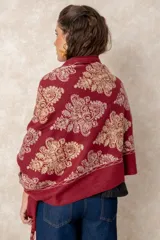 Pashmina de tela densa y suave, con caída pesada y diseño bordado con motivos florales en tonos dorados y beige. Presenta terminaciones con flecos en los extremos.