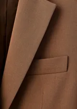 Blazer estructurado de corte recto, con cuello de solapa con muesca, cierre frontal de un botón y bolsillos laterales con solapa.