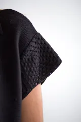 Vestido corto negro con cuello polo y detalle de calados en el ruedo y en la parte superior.