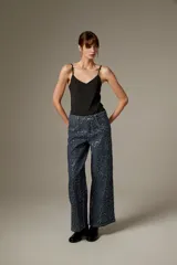 Body negro con tirantes finos, escote en V pronunciado y corte ajustado al cuerpo, con detalles bordados sutiles.