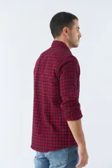 Camisa de viyela a cuadros negros, blancos y rojos, de corte slim fit, con bolsillos en el pecho, manga larga y cierre con botones.