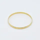 Esclava rígida tipo bombé de diseño minimalista, fabricada en oro 18k con acabado pulido brillante.