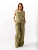 Pantalón de lino de corte holgado y tiro ajustable, con cintura elástica y cordón. Presenta bolsillos laterales y un bolsillo trasero.