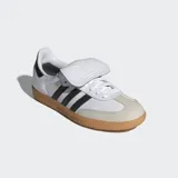 Championes Adidas Samba LT de diseño retro, confeccionados en cuero de primera calidad con puntera de nobuk. Presentan las icónicas tres bandas laterales en negro, suela de goma color caramelo y una lengüeta extragrande inspirada en las botas de fútbol clásicas.