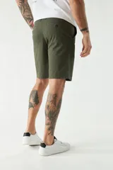 Bermuda tipo chino color verde oliva, con corte clásico, bolsillos laterales y traseros, cierre frontal y pasacintos.