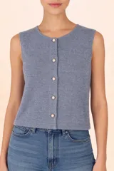 Chaleco de punto color gris, sin mangas, con cuello redondo y cierre frontal mediante botones decorativos tipo perla.
