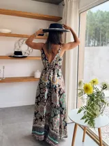 Vestido largo de satén con estampado de mandalas en tonos blanco, verde, marrón y naranja. Tiene breteles finos y corte imperio con cinturón marrón con hebilla dorada.