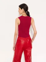 Top color borgoña de hilado frío, corte ajustado y largo hasta la primera cadera. Sin mangas, con cuello redondeado y profundo.