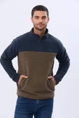 Buzo de polar texturado con diseño bicolor en azul marino y marrón, cuello alto con medio cierre y bolsillos laterales.