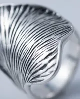 Anillo de plata 925 con diseño frontal amplio y texturizado en bajo relieve con acabado pavonado.