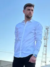 Camisa de manga larga color blanco, con cuello clásico y cierre frontal de botones.