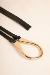 Cinturón negro de tiras finas en símil cuero que se atan pasándolas por la hebilla metálica dorada.