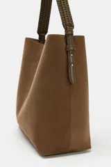 Bolso de hombro formato saca en color marrón, con asa superior trenzada y cierre mediante clip metálico. Incluye compartimento interior extraíble con cremallera.