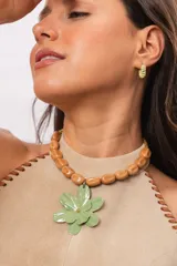 Collar corto de cristales rojos facetados con un gran dije colgante en forma de flor celeste pintada a mano.