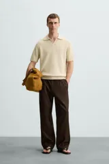 Polo color beige de punto con cuello solapa y manga corta.