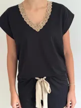 Pijama celeste de algodón con textura acanalada, compuesto por una remera de mangas cortas con escote en V y puntilla blanca, y un short con elástico en la cintura, lazo y terminación con puntilla.