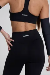 Calza larga negra de tiro alto, confeccionada en tejido de poliamida y elastano.