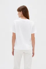 Remera de algodón blanca, de manga corta y cuello redondo, con estampado frontal de texto en color negro.