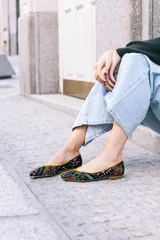 Bailarinas negras con estampado multicolor y ribete naranja.