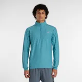 Buzo deportivo de running New Balance con cierre frontal de un cuarto, cuello alto y mangas largas con orificios para los pulgares. Presenta un diseño en tejido técnico transpirable con tecnología NB DRY y logo reflectante en el pecho.