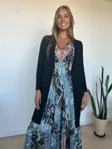 Saco de hilo de seda y lycra, color negro, de corte largo con bolsillos laterales con detalles de cierres y tiradores metálicos.