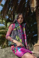 Chaleco puffer reversible con estampado abstracto en tonos negro, verde, violeta y fucsia.