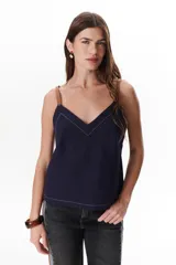 Musculosa azul marino de lino con escote en V, breteles de cuero marrón y pespuntes blancos decorativos.