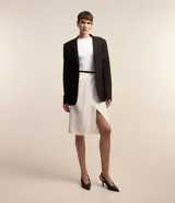 Pollera lápiz color blanco, de sastrería, con cinturón de cuero sintético negro y detalle plegado en la parte delantera.