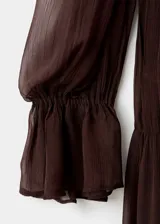 Vestido midi de gasa color marrón, con cuello alto, manga larga abullonada, panel fruncido en la cintura y falda plisada con forro interior.