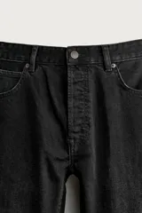 Jeans regular fit de mezclilla negra con efecto lavado, corte recto y tiro medio. Cuenta con diseño de cinco bolsillos y cierre frontal con cremallera y botón.