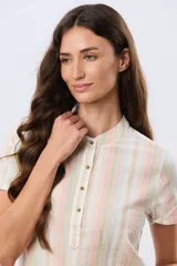 Camisa de lino de manga corta con cuello mao y cierre frontal parcial con botones. Presenta un diseño de rayas verticales en tonos suaves como rosa, verde, celeste y beige.