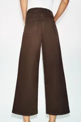 Jeans de tiro alto con diseño wide leg y corte cropped. Presenta cinco bolsillos, cierre frontal con cremallera y botón metálico.