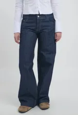 Jean de corte recto y tiro medio, confeccionado en denim azul oscuro con costuras en contraste.