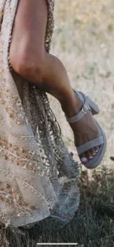 Sandalias de tacón alto de gamuza color beige, con tira delantera, plataforma y tira ajustable al tobillo con hebilla metálica.