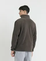 Campera de micropolar color verde oscuro, con cuello alto, cierre frontal completo, bolsillos laterales y un bolsillo con cierre en el pecho.